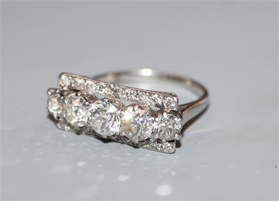A five stone diamond and white metal (tests as platinum) line-set dress ring, with diamond set borders, size M.